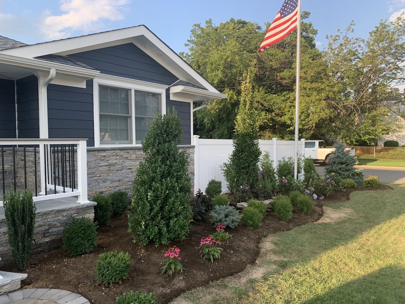 Front yard with fresh plantings and a flagpole